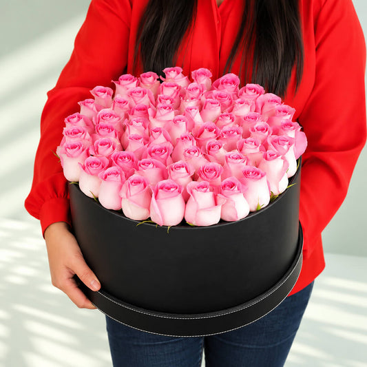 Charming pink roses in a black round flower box, featuring 50 to 60 fresh roses for elegant gifting.