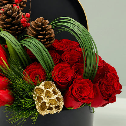Christmas festive flower box featuring red roses, exotic blooms, pinecones, foliage, and seasonal accents