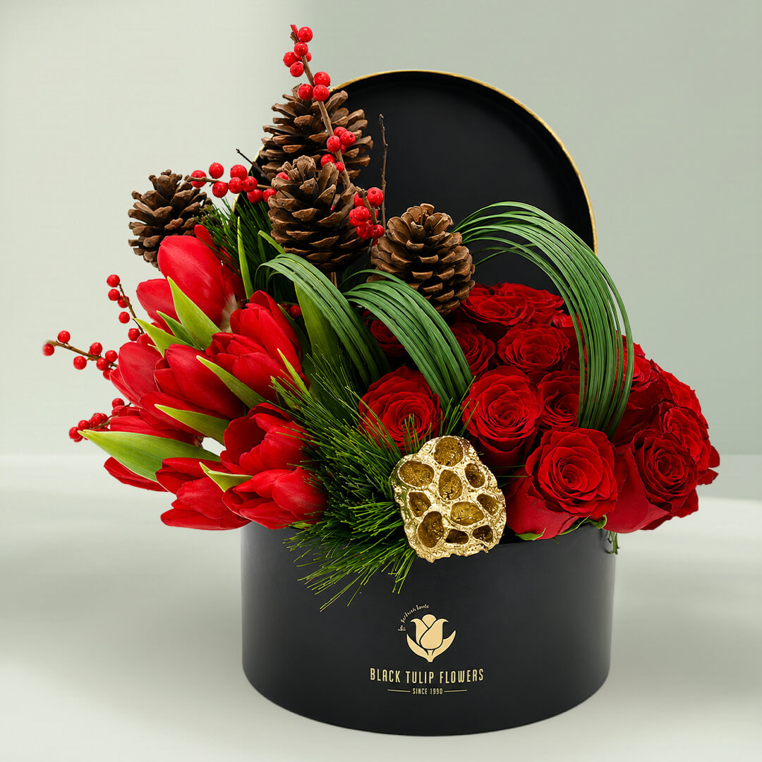 Christmas festive flower box featuring red roses, exotic blooms, pinecones, foliage, and seasonal accents