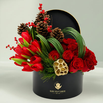 Christmas festive flower box featuring red roses, exotic blooms, pinecones, foliage, and seasonal accents