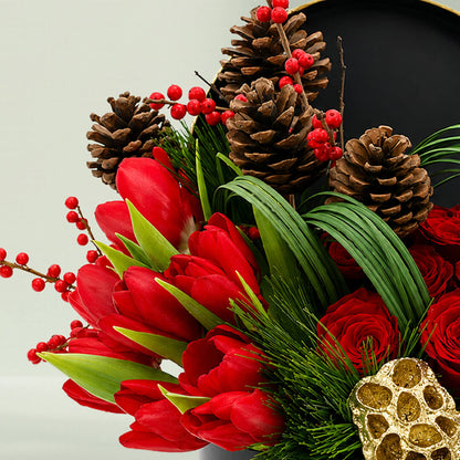 Christmas festive flower box featuring red roses, exotic blooms, pinecones, foliage, and seasonal accents