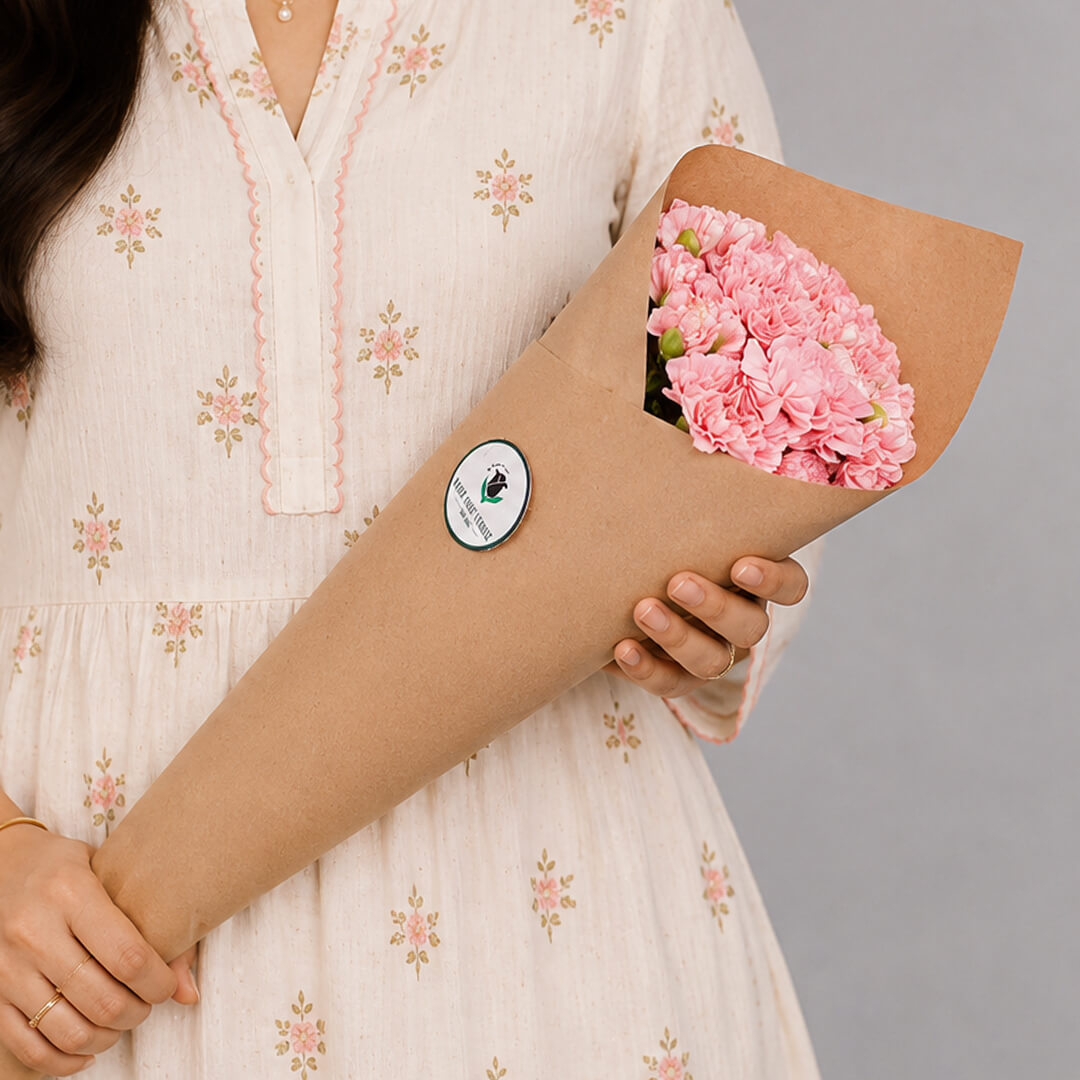 Fresh Carnation blooms neatly arranged in brown paper wrapping