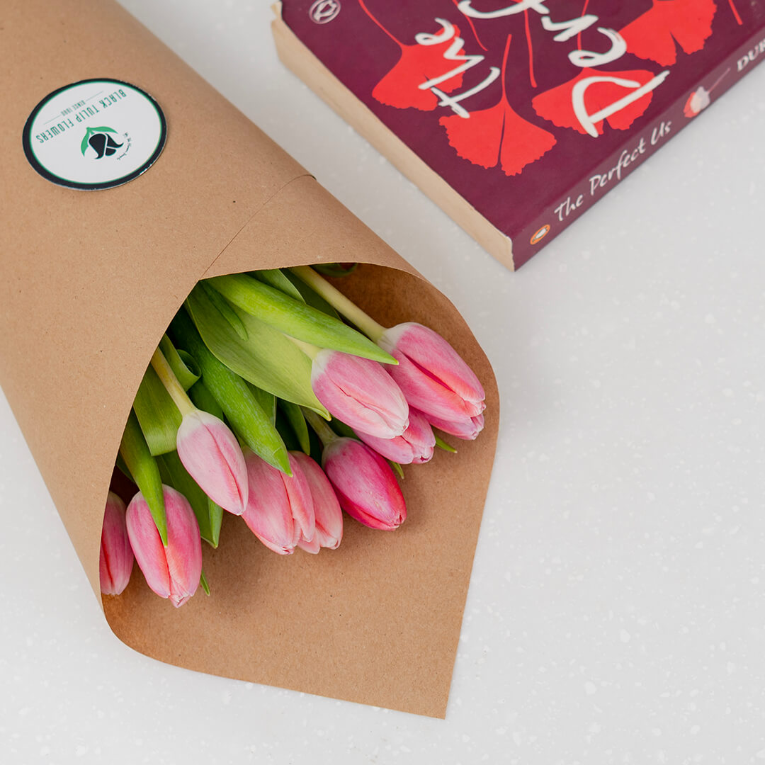 Vibrant dark pink cut tulips arranged in a glass vase showing rich magenta petals