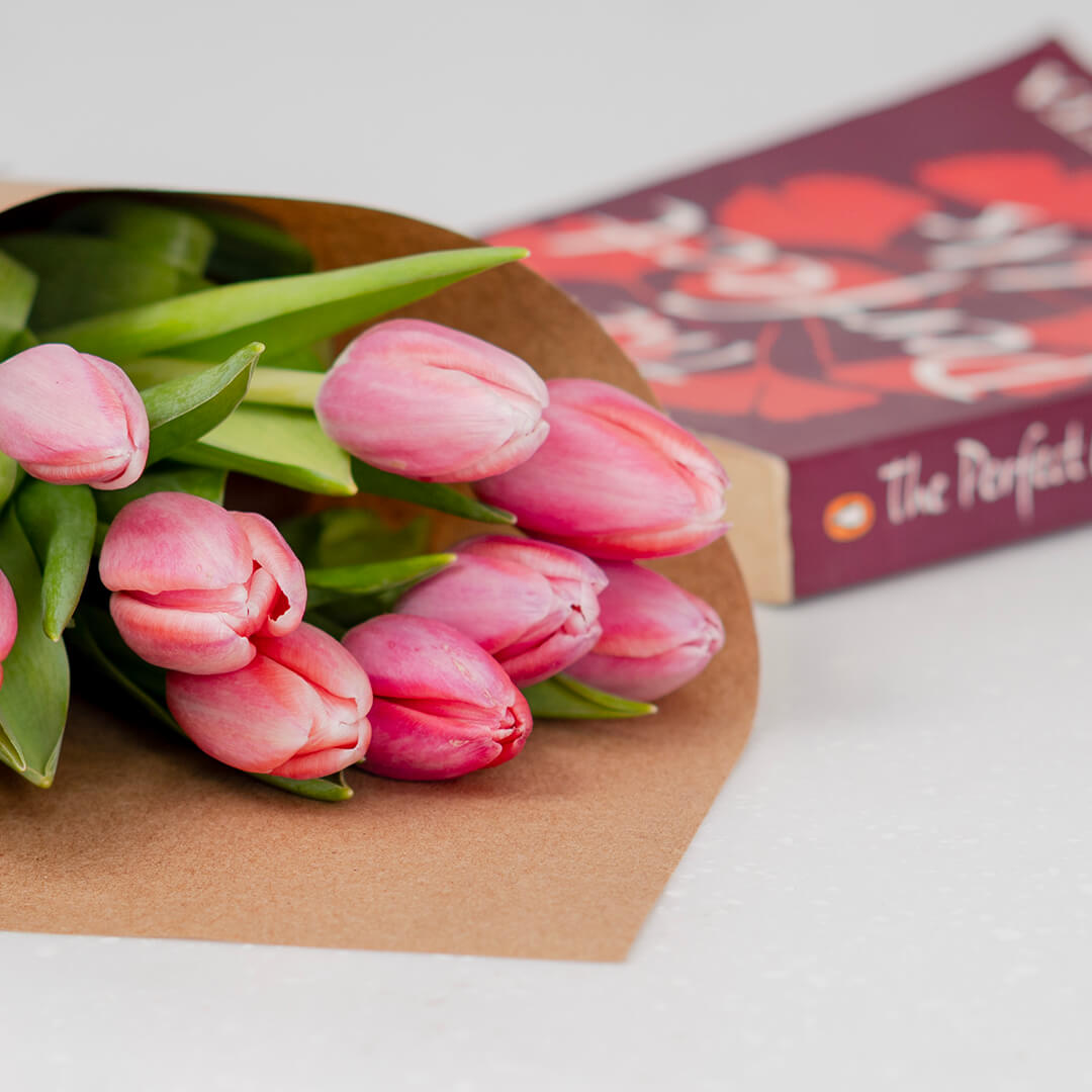 Vibrant dark pink cut tulips arranged in a glass vase showing rich magenta petals
