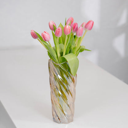 Vibrant dark pink cut tulips arranged in a glass vase showing rich magenta petals