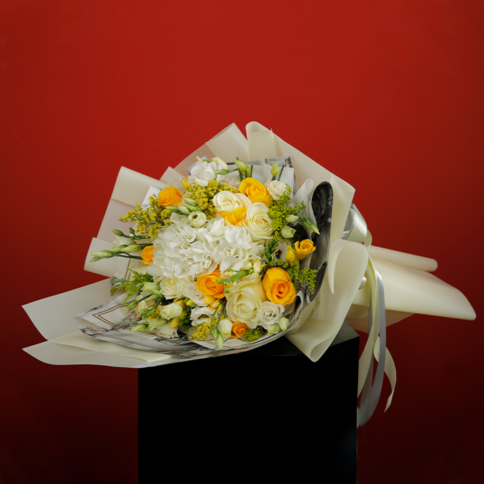 Bouquet featuring roses, Eustoma, golden rod and fillers in white non-woven wrapping, finished with elegant ribbons.