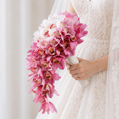 White and pink cymbidium orchid flowers arranged in a modern hand-tied minimalist design