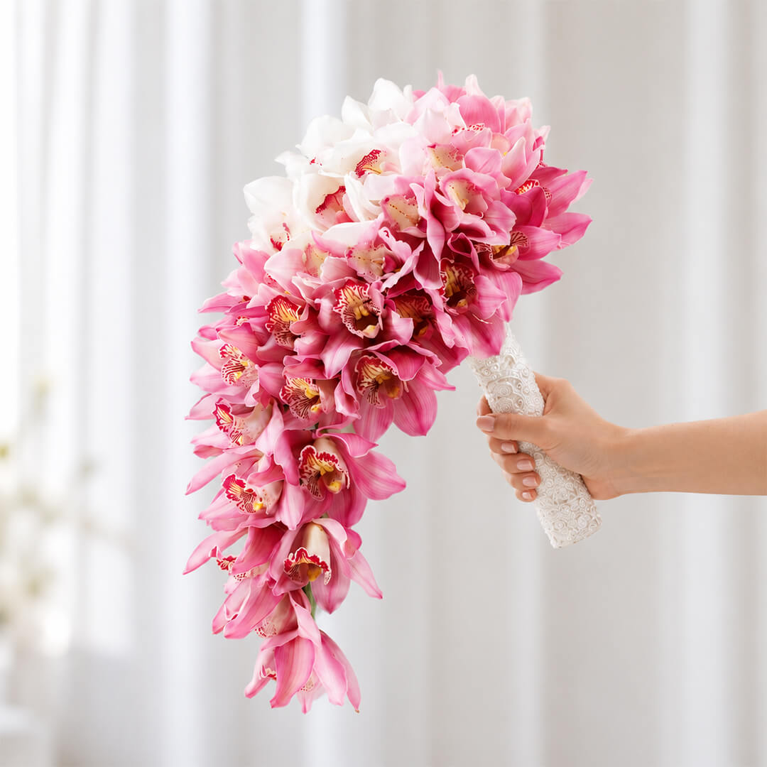 White and pink cymbidium orchid flowers arranged in a modern hand-tied minimalist design