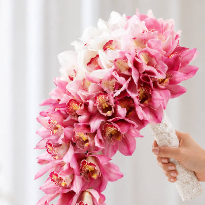 White and pink cymbidium orchid flowers arranged in a modern hand-tied minimalist design