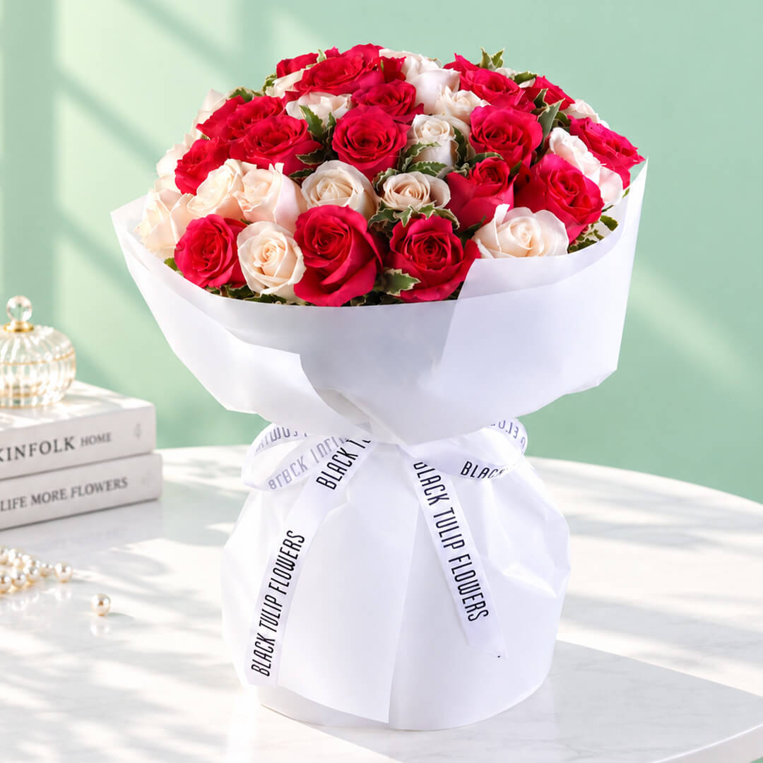 35 red and white roses in a neatly wrapped floral bouquet