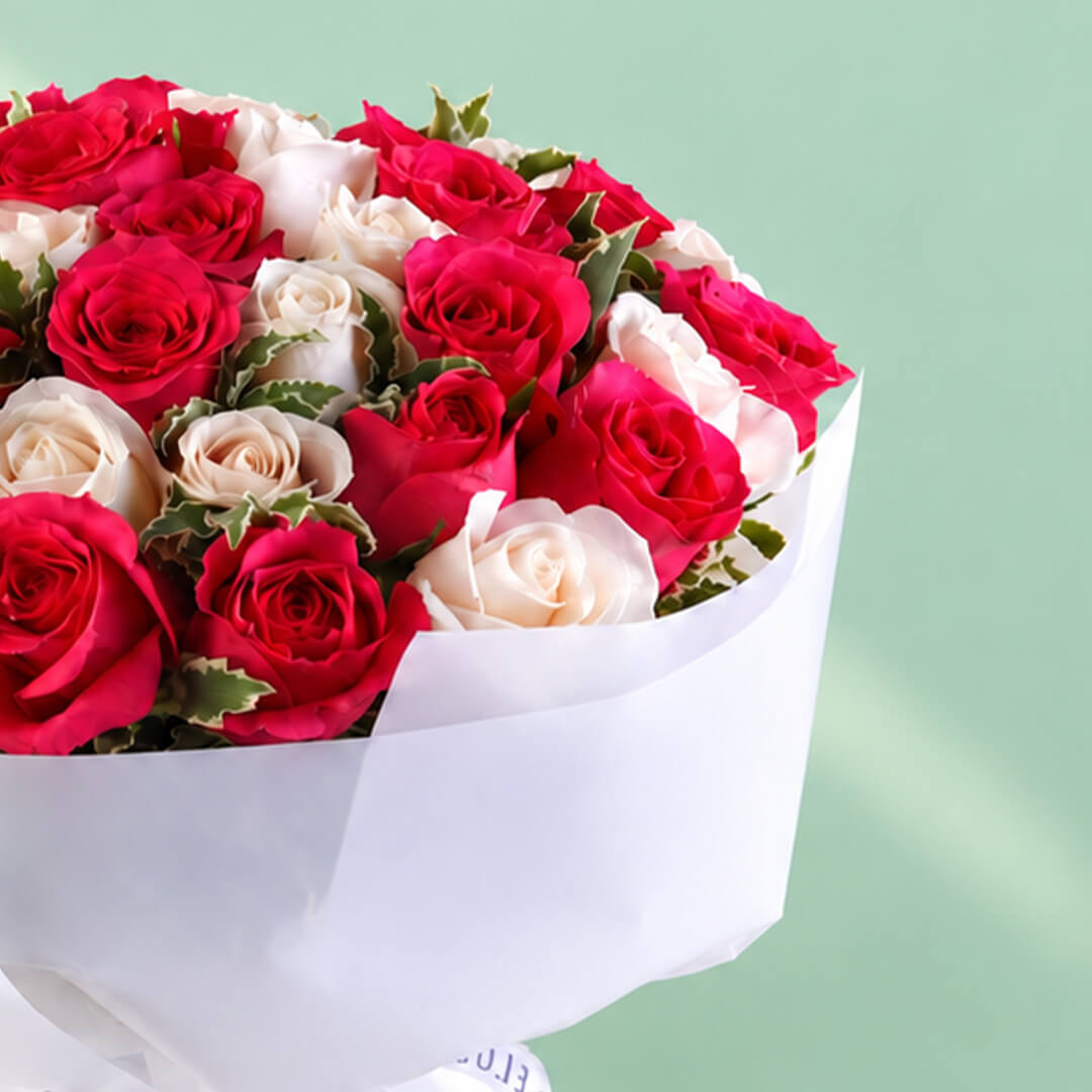 35 red and white roses in a neatly wrapped floral bouquet