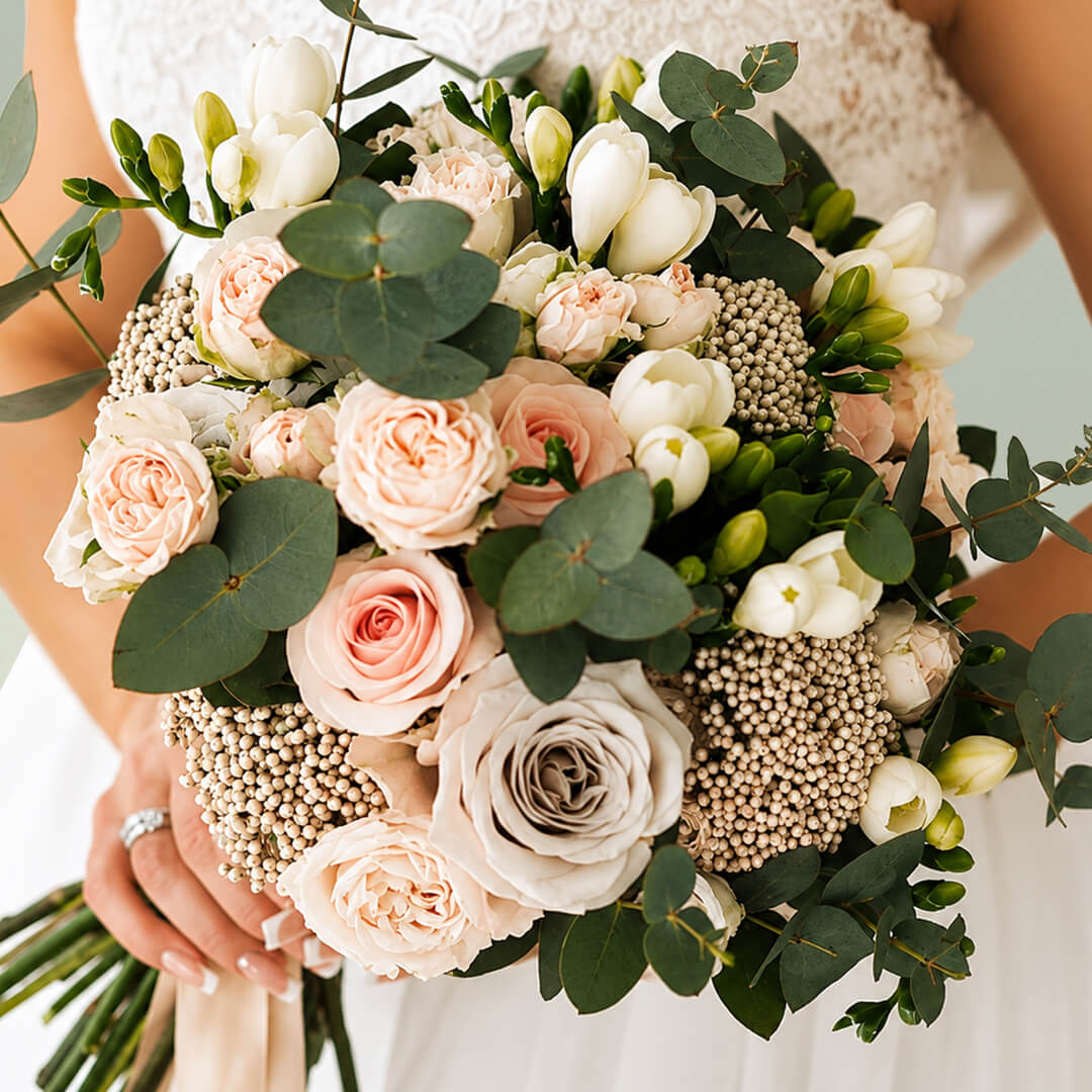 Exotic bridal bouquet with blush pink roses, seasonal flowers and fresh eucalyptus greenery for weddings