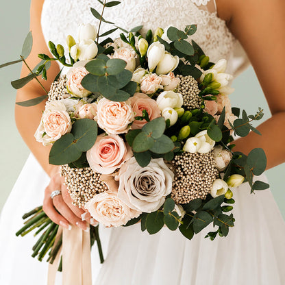 Exotic bridal bouquet with blush pink roses, seasonal flowers and fresh eucalyptus greenery for weddings