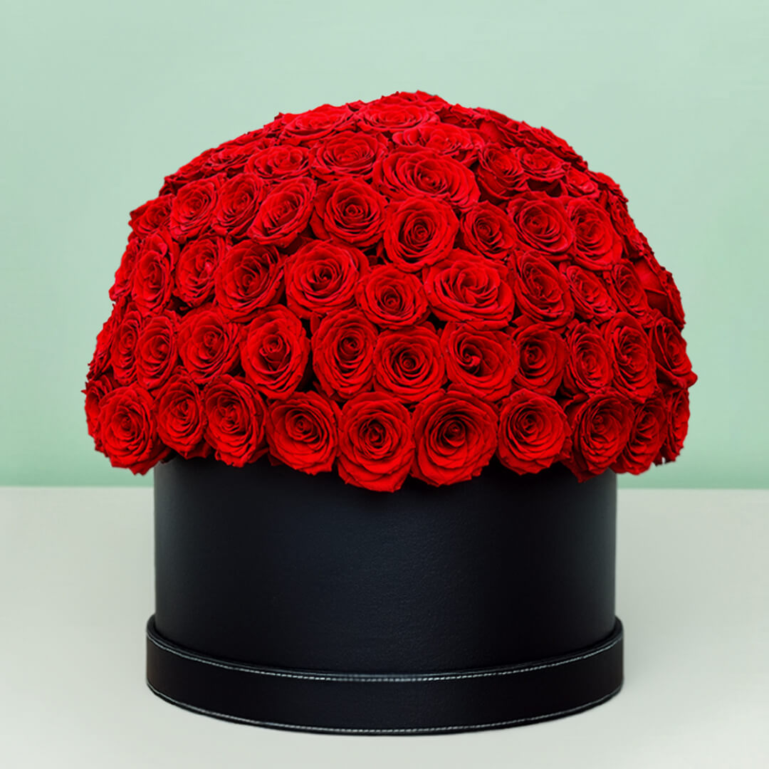 Grand red rose hat box featuring 55–60 romantic red roses in a full dome arrangement