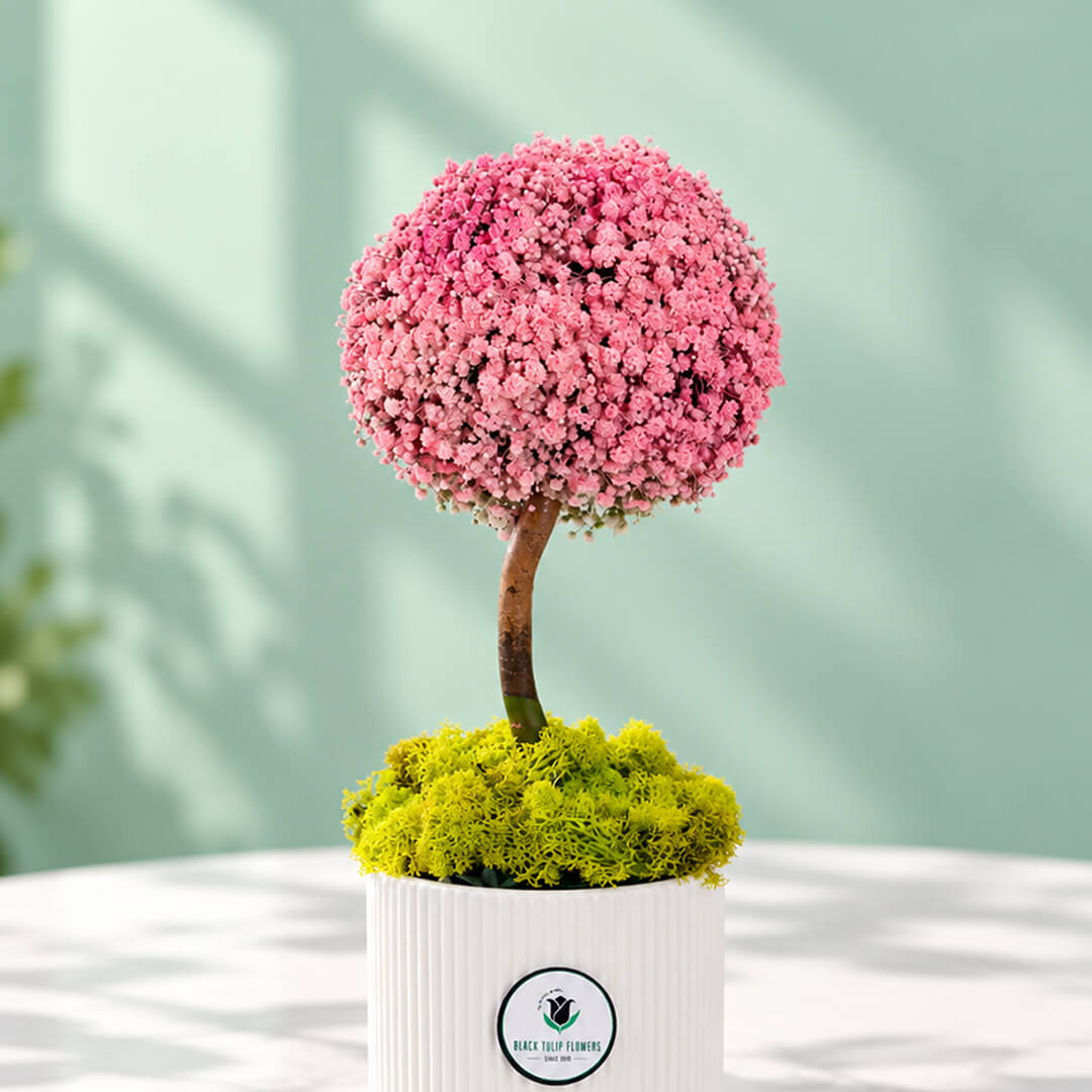 Gypso and green moses floral arrangement displayed in a ceramic vase