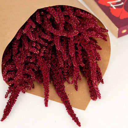 Hanging Amaranthus cut flowers in red colour wrapped in brown paper