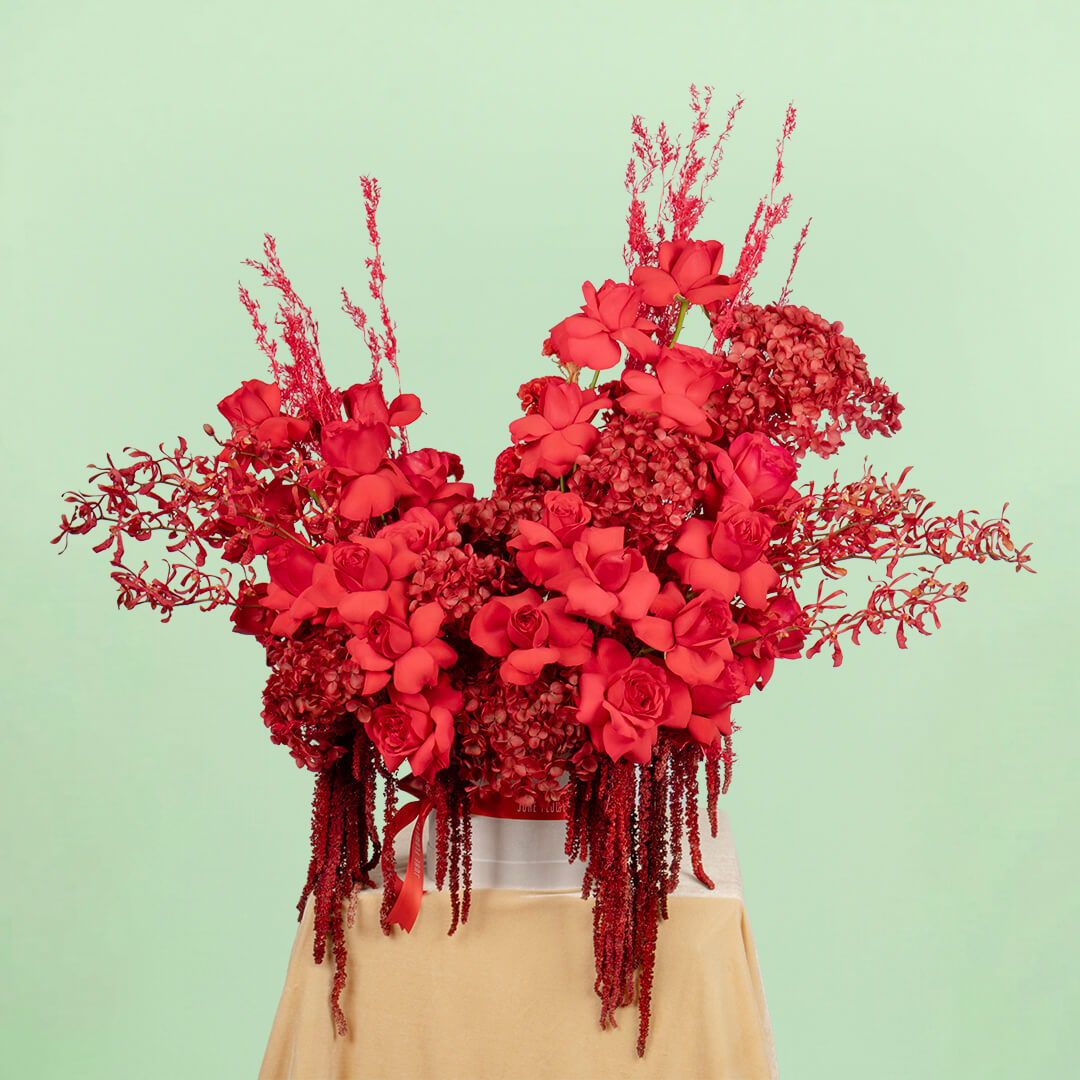 Red flower box with hydrangea, roses, orchids and dried flowers

