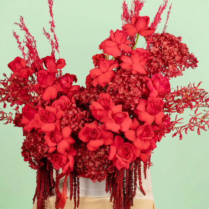 Red flower box with hydrangea, roses, orchids and dried flowers