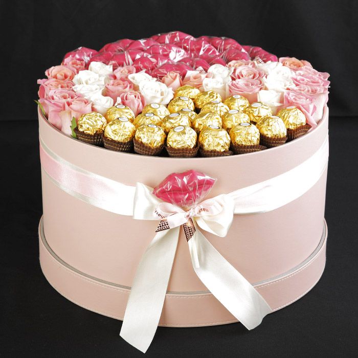 Round flower box featuring assorted roses and 16 Ferrero Rocher chocolates in an elegant luxury arrangement.