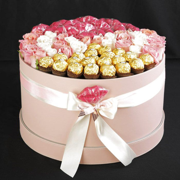 Round flower box featuring assorted roses and 16 Ferrero Rocher chocolates in an elegant luxury arrangement.