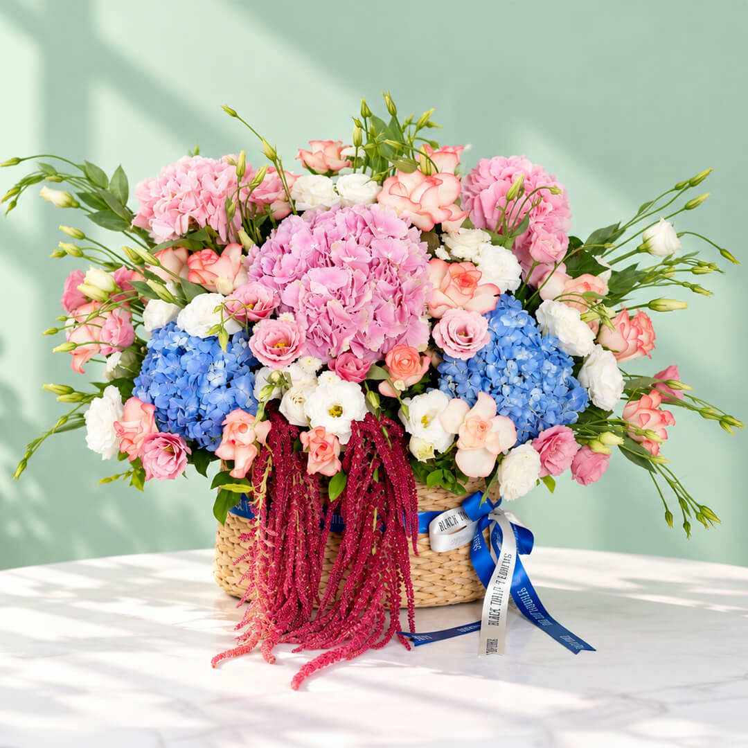 Mixed floral basket with hydrangea, roses, eustoma and amaranthus arranged in a rectangular basket
