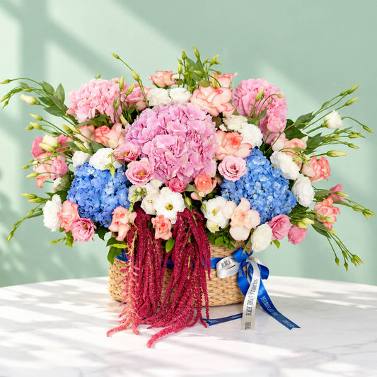 Mixed floral basket with hydrangea, roses, eustoma and amaranthus arranged in a rectangular basket