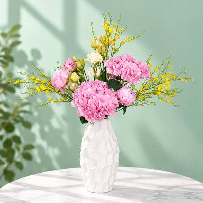 Pink and yellow flower arrangement with peony, hydrangea and orchids in a ceramic vase