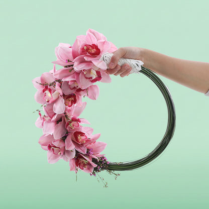 Elegant circular bridal hoop with pink Cymbidium orchids and wax flowers