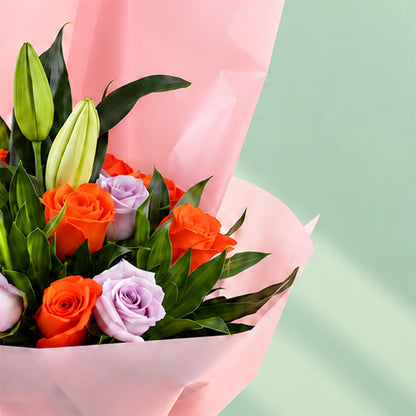 Lilies, Roses, and Green leaves combined as a bouquet and wrapped by non-woven paper