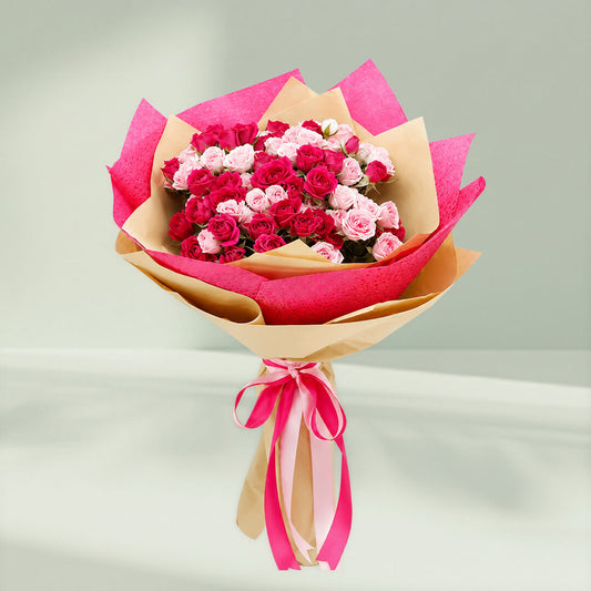 pink spray rose bouquet with layered wrapping and matching ribbons for special occasions