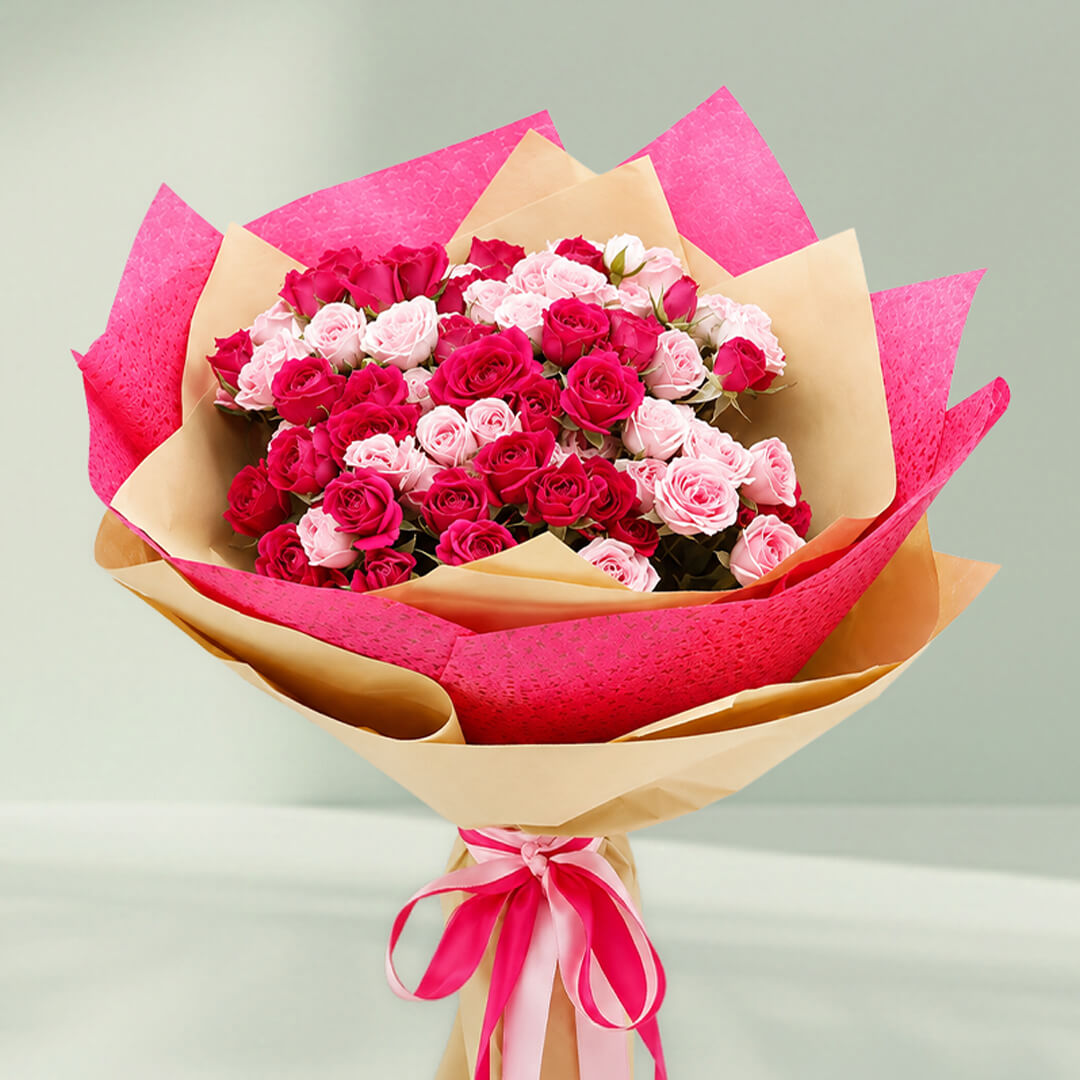 pink spray rose bouquet with layered wrapping and matching ribbons for special occasions