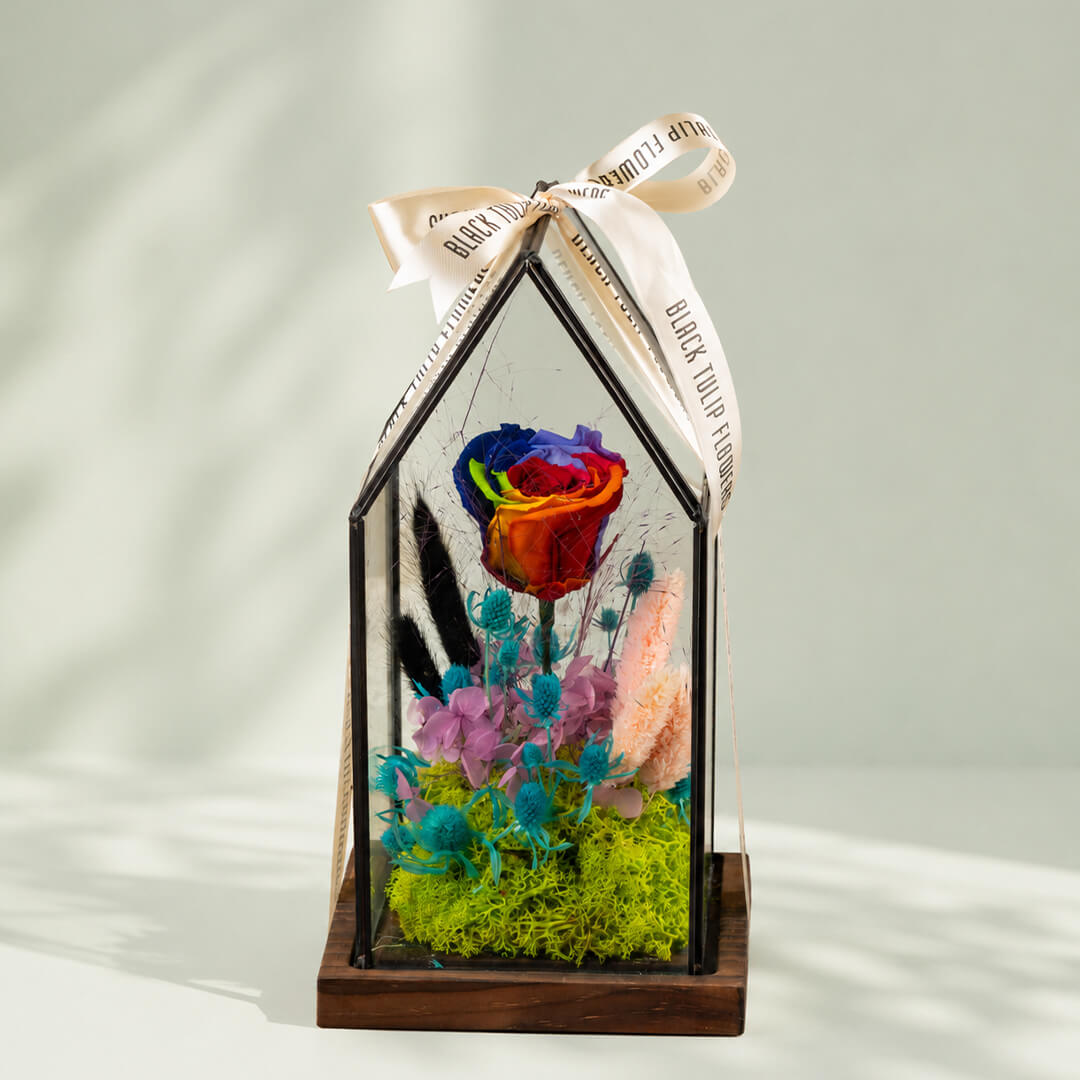 Preserved rainbow rose with dried flowers displayed elegantly in a decorative glass dome