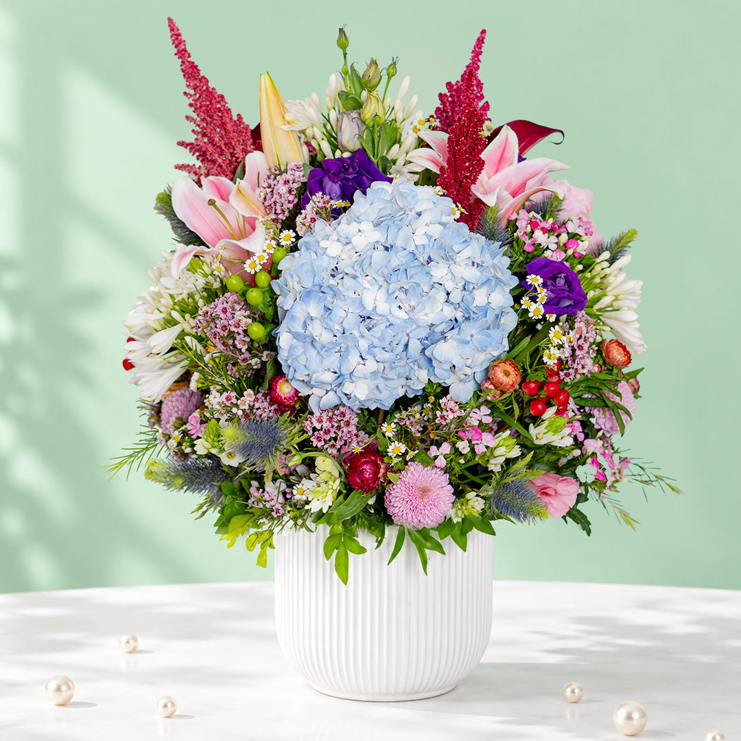 Exotic flower vase with protea, hydrangea, pincushion, lilies and greenery