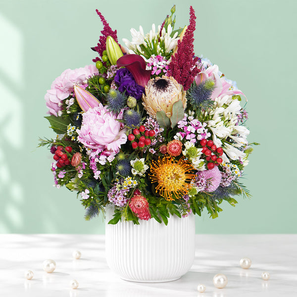 Exotic flower vase with protea, hydrangea, pincushion, lilies and greenery