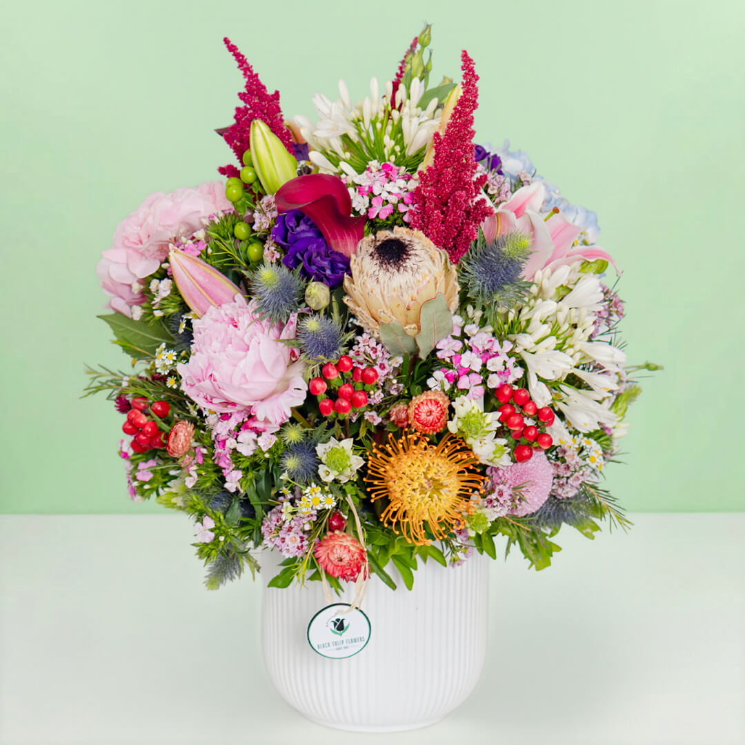 Exotic flower vase with protea, hydrangea, pincushion, lilies and greenery
