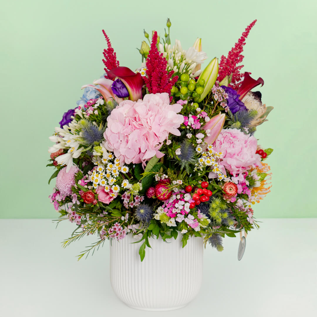 Exotic flower vase with protea, hydrangea, pincushion, lilies and greenery