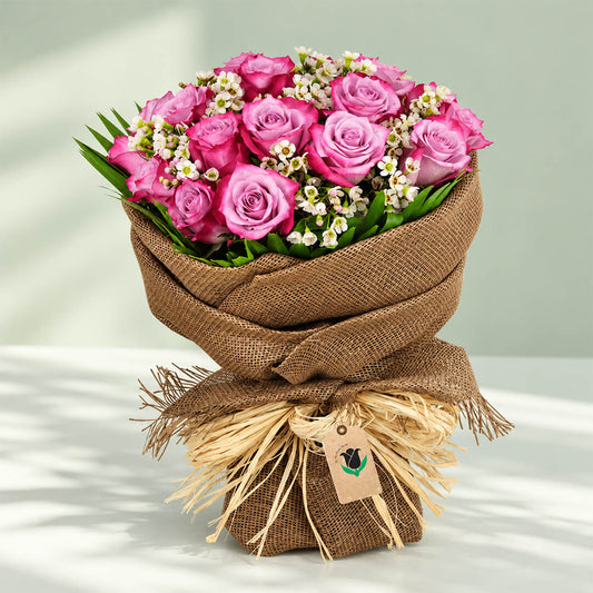Purple rose bouquet with delicate wax flowers in natural jute wrapping for elegant gifting occasions