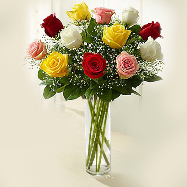 A transparent glass cylinder vase arrangement featuring 12 assorted roses, baby’s breath and greenery.
