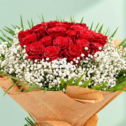 A bouquet featuring 30 red roses with delicate white gypso flowers nestled between the roses and a neat non-woven paper finish