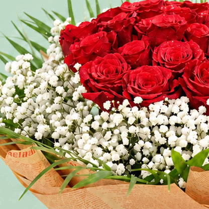 A bouquet featuring 30 red roses with delicate white gypso flowers nestled between the roses and a neat non-woven paper finish