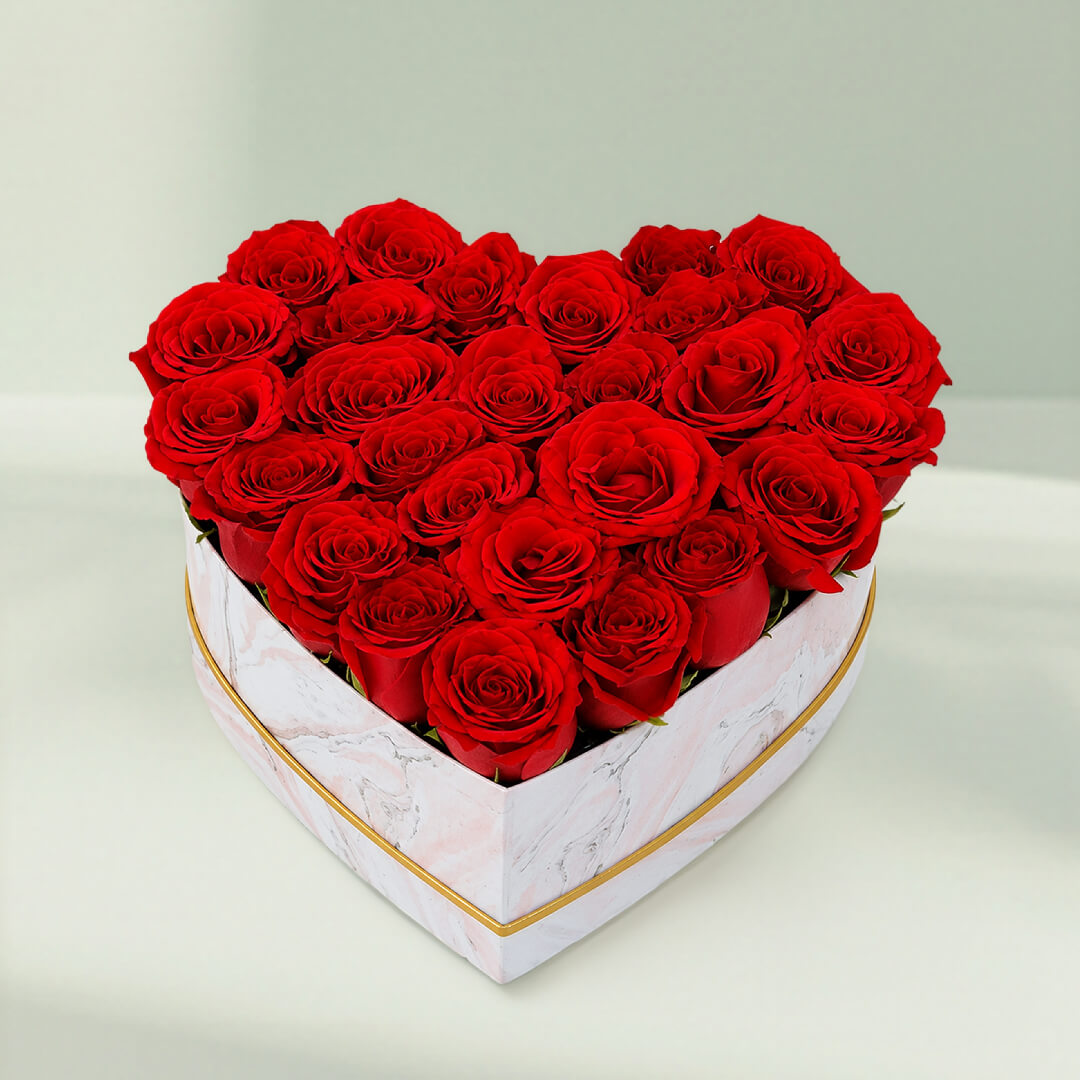 Fresh red roses arranged in a white heart-shaped marbled box for romantic gifting