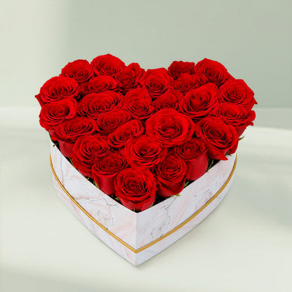 Fresh red roses arranged in a white heart-shaped marbled box for romantic gifting