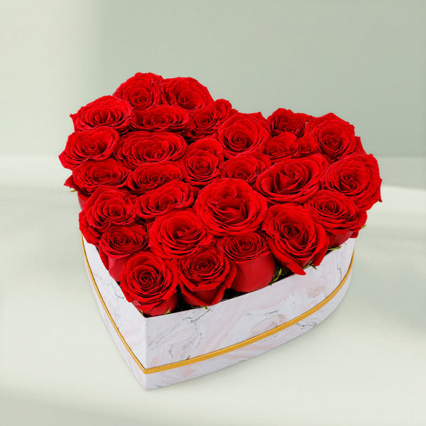 Fresh red roses arranged in a white heart-shaped marbled box for romantic gifting