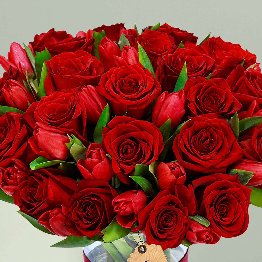 Red roses and tulips arranged beautifully in a stylish vase for elegant gifting occasions