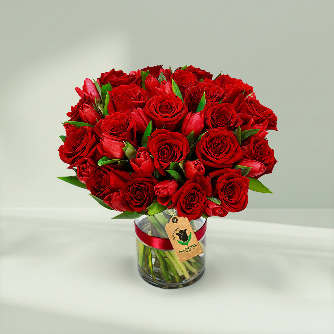 Red roses and tulips arranged beautifully in a stylish vase for elegant gifting occasions