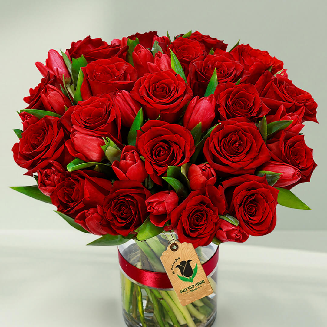 Red roses and tulips arranged beautifully in a stylish vase for elegant gifting occasions