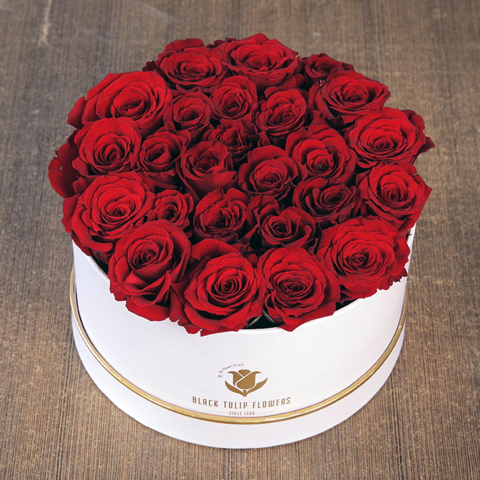 Round flower box featuring 25 to 35 red roses in a premium white box with gold detailing