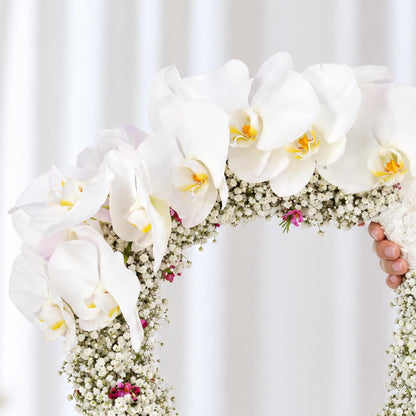 White Cymbidium bridal wreath with Gypsophila, wax flowers, and steel grass in a circular design