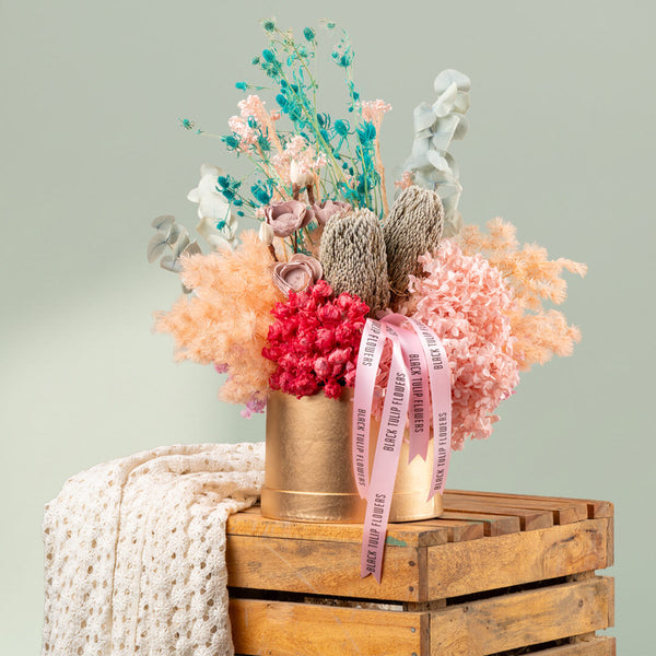 Luxury round gold box filled with assorted dried preserved flowers for elegant gifting and stylish interiors