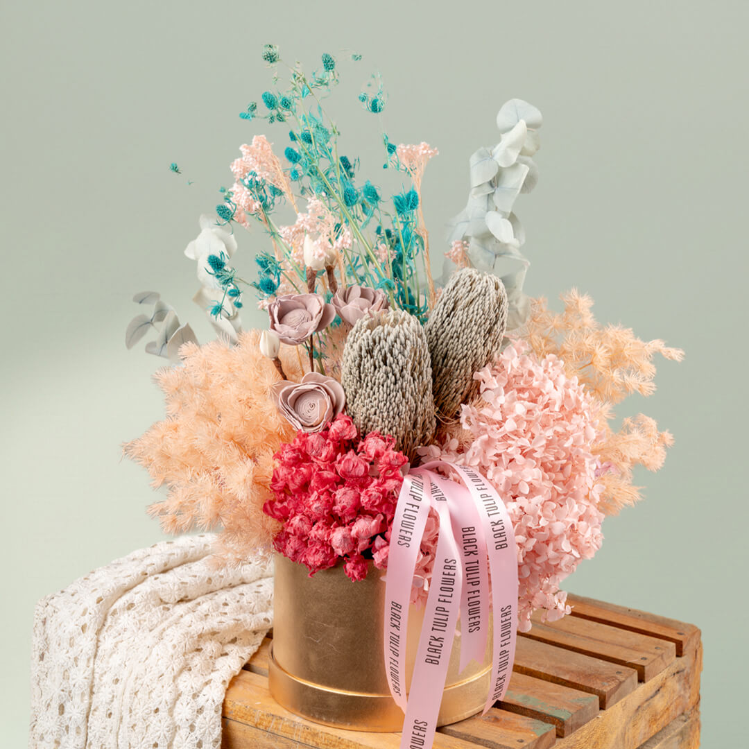 Luxury round gold box filled with assorted dried preserved flowers for elegant gifting and stylish interiors